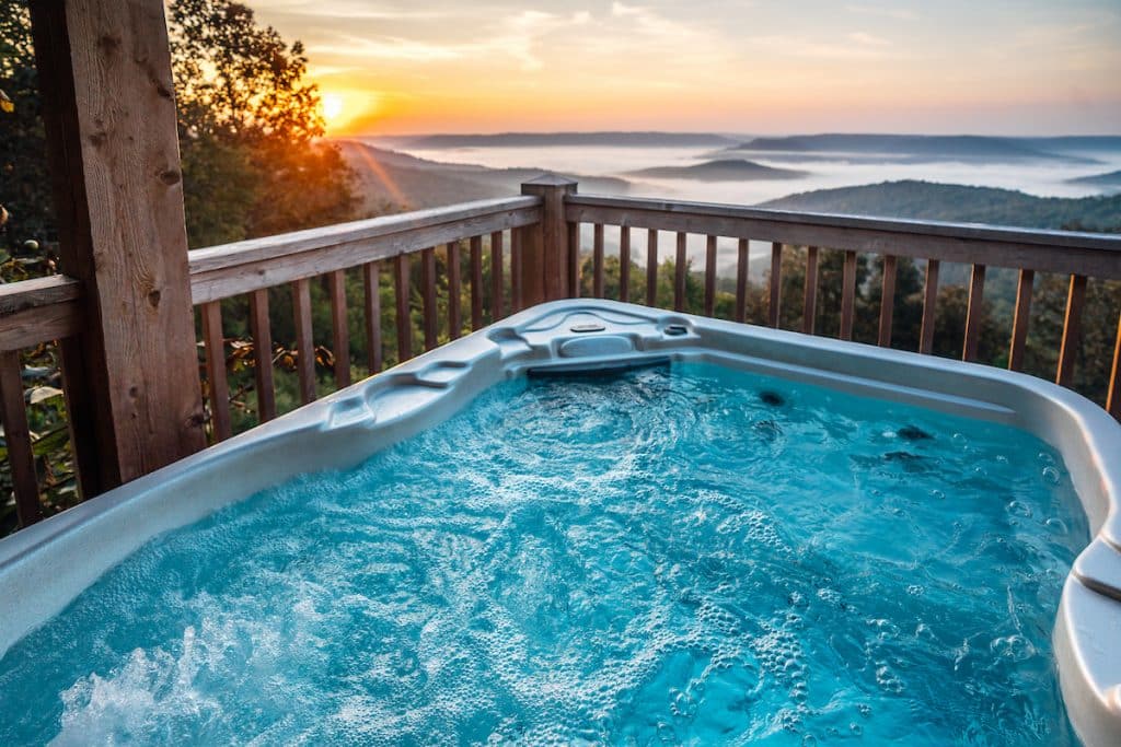 A bubblng hot tub with a sunrise view across the Ozark Mountains.